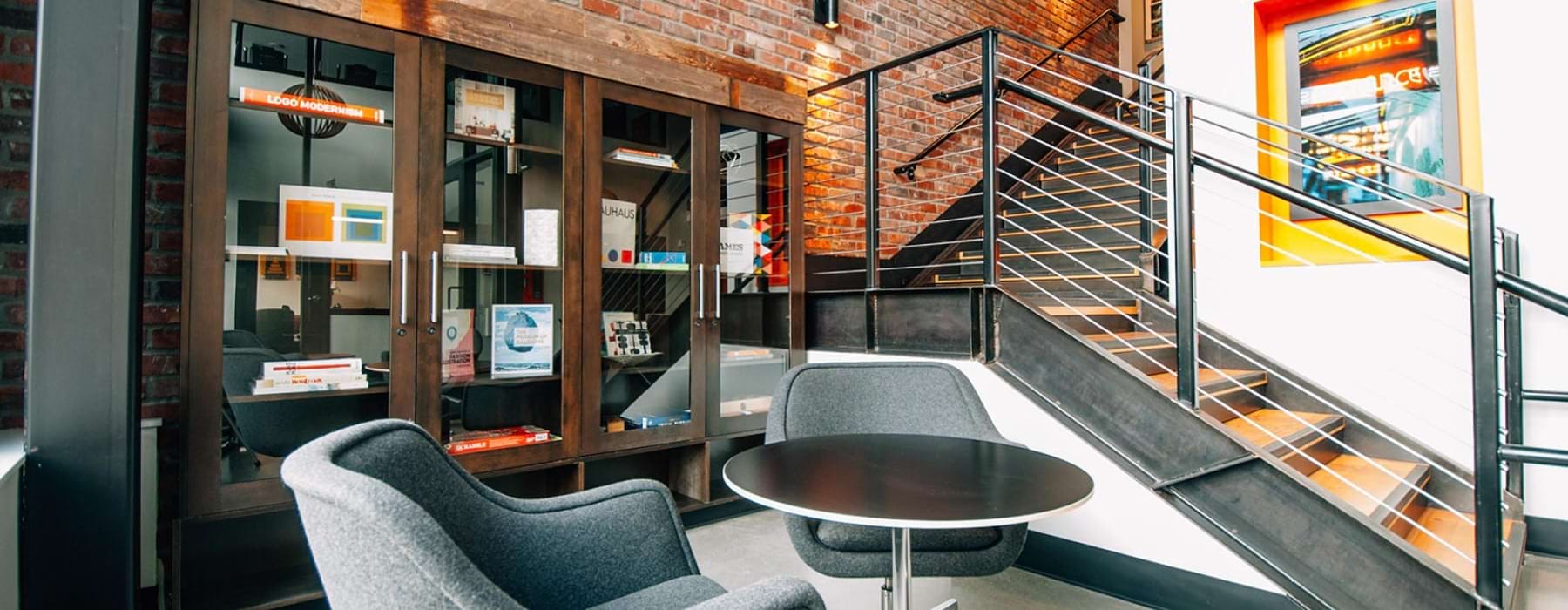 a brick wall with stairs and a chair and table
